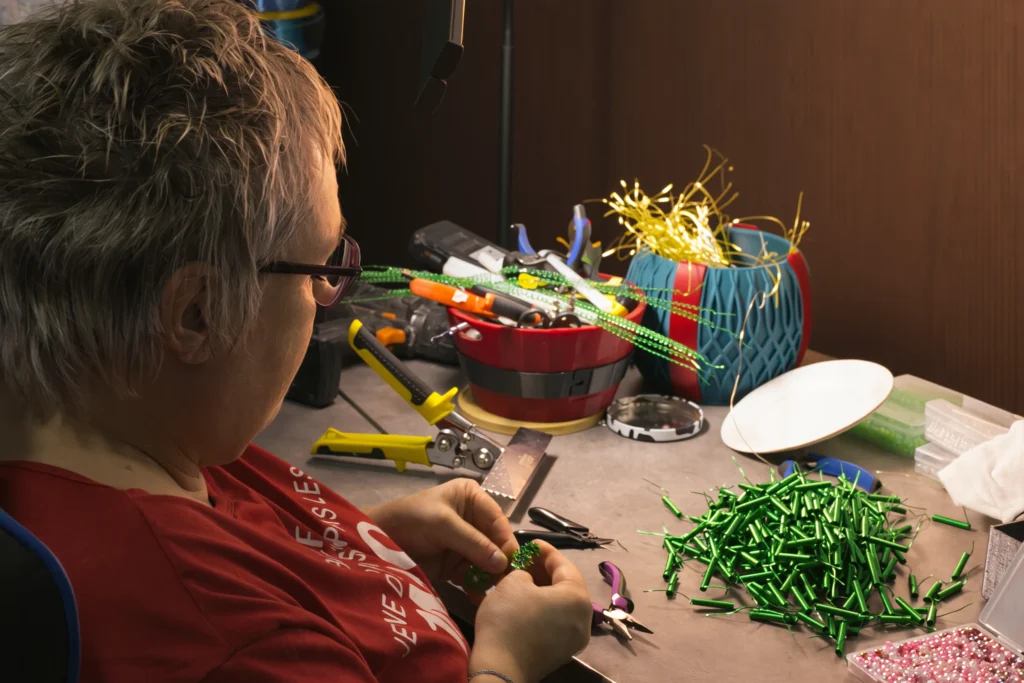 Odile façonnant à la main un bonsaï en fil d'aluminium dans son atelier